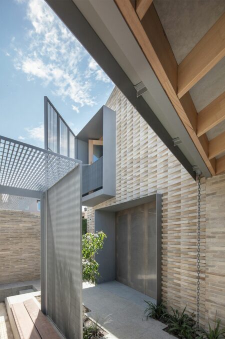 Divided House: Two Primary Brick Building Forms with A Continuous Design