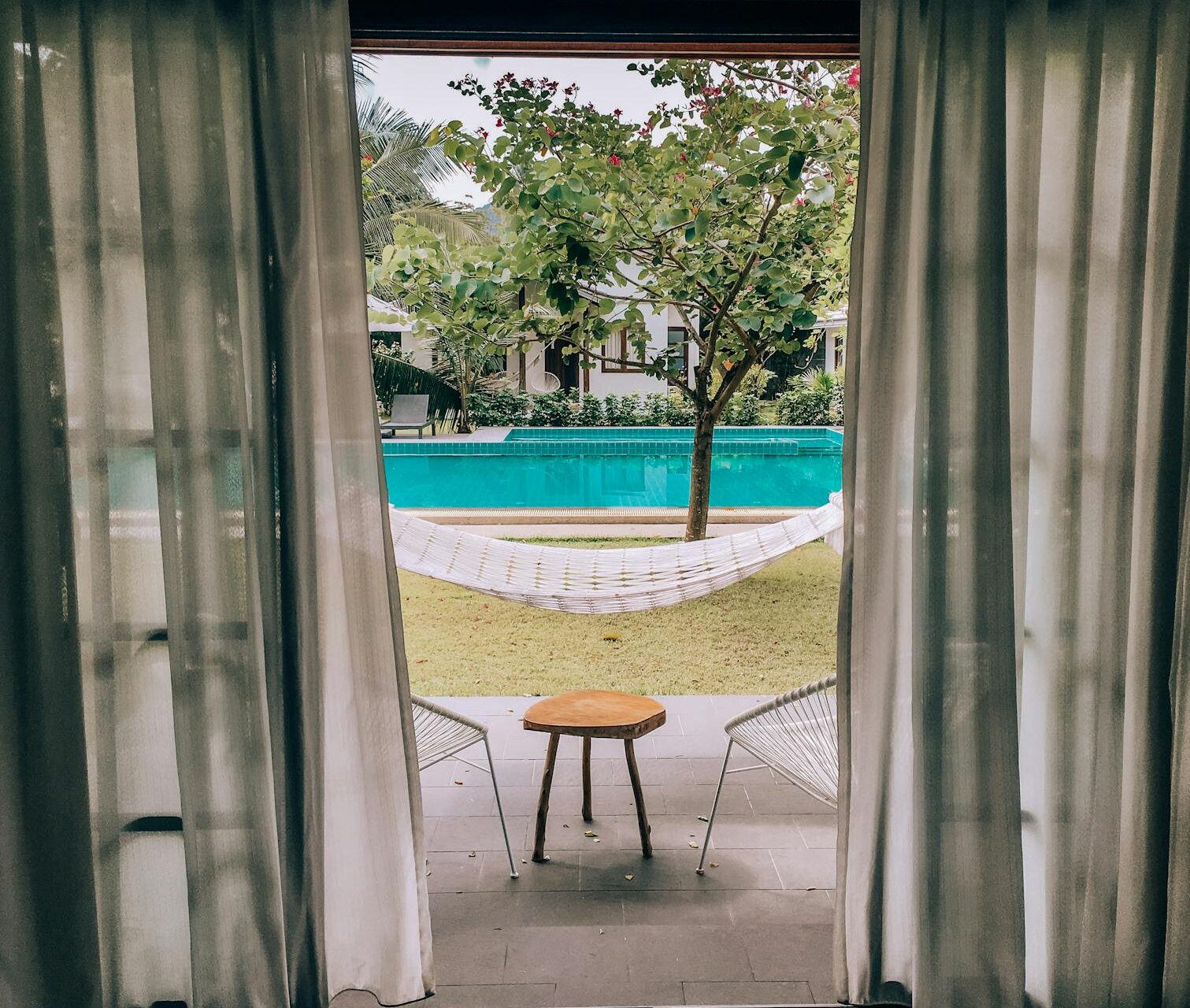 brown wooden table near swimming pool