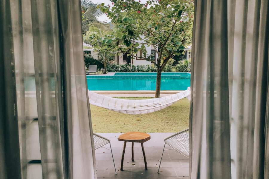 brown wooden table near swimming pool