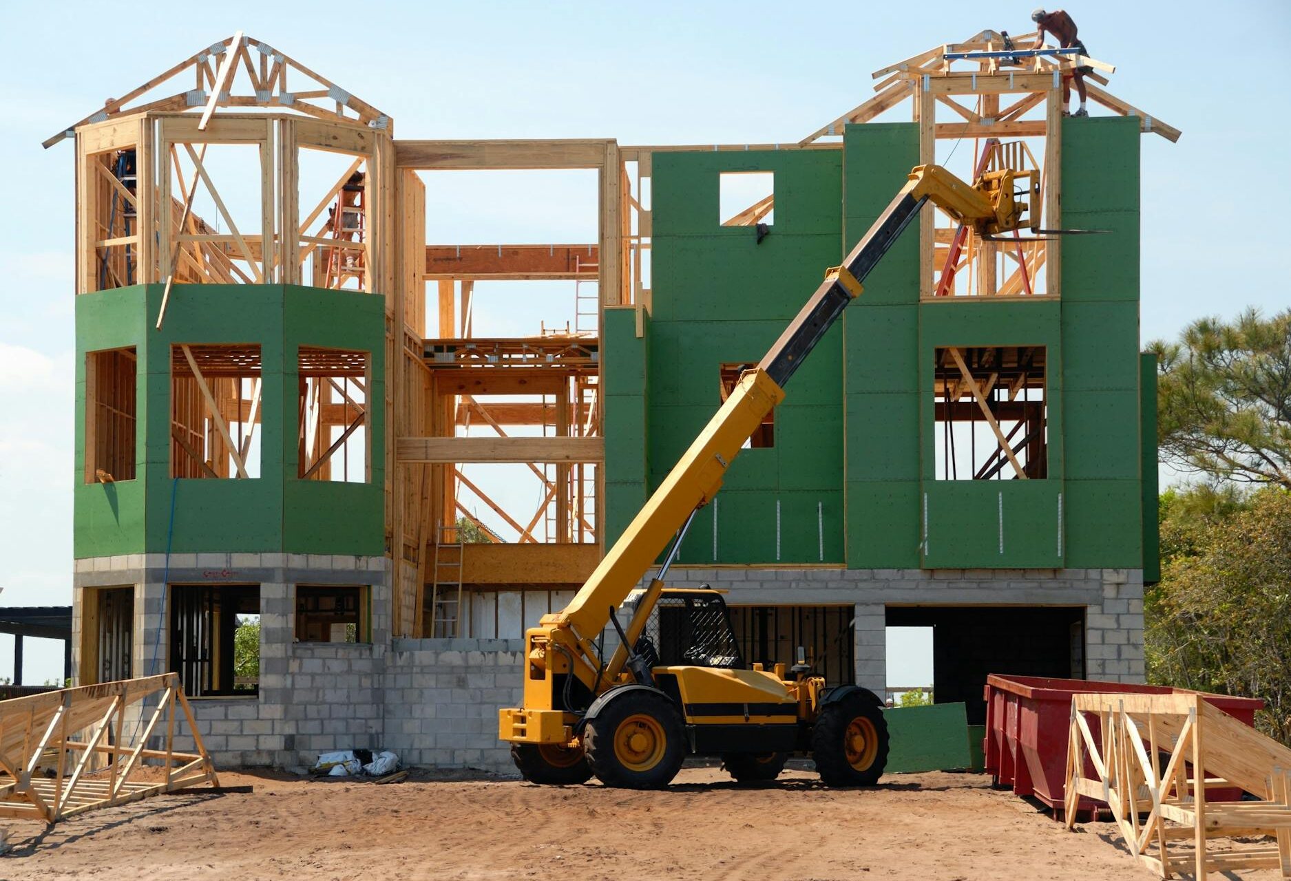 yellow and black heavy equipment near unfinished building