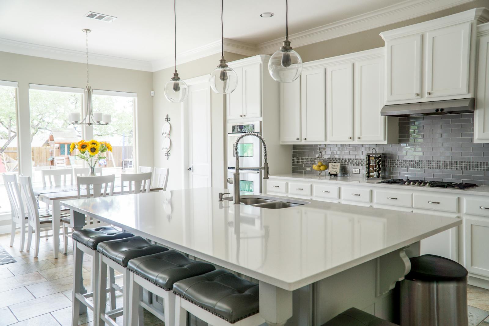 Spacious modern kitchen with white cabinets and island in natural light.