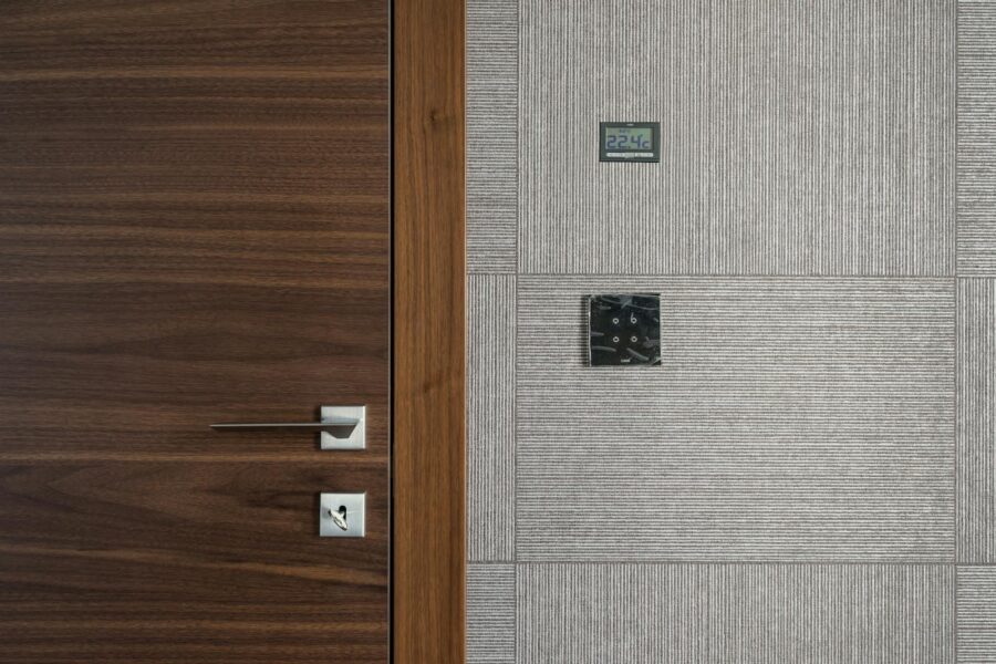 Sleek modern wooden door with stainless steel handle and 22.4°C display.