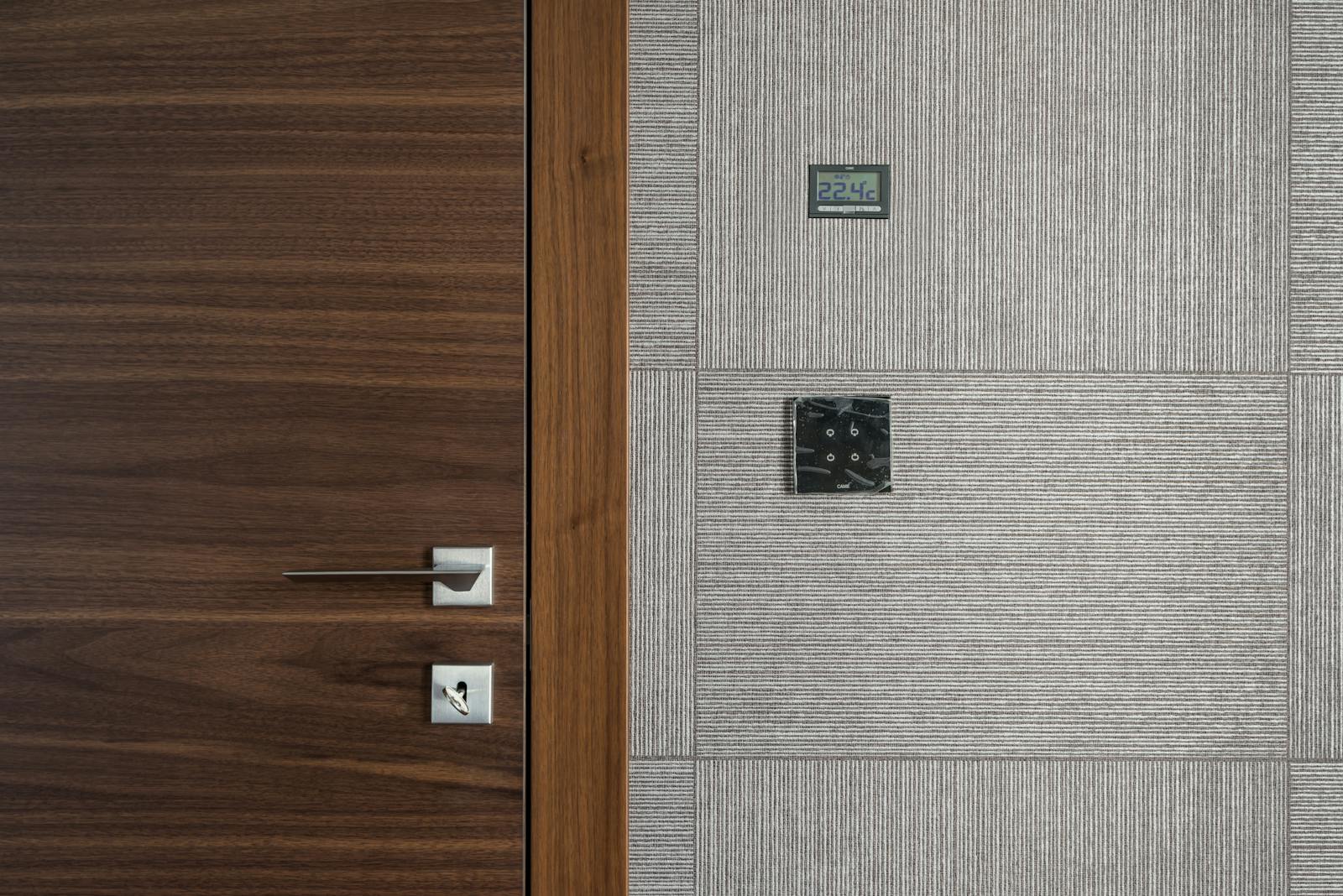 Sleek modern wooden door with stainless steel handle and 22.4°C display.